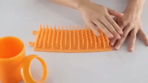 Soft removable silicone sleeve being prepared for a dog paw cleaner cup